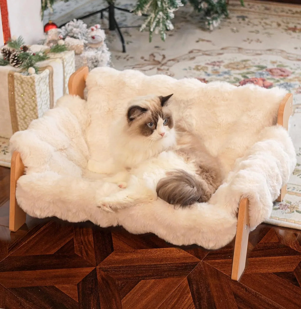 Beige cotton cat bed with wooden sofa-style frame and removable washable cover