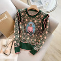 Green loose-fit printed sweater with regular sleeves on a hanger.
