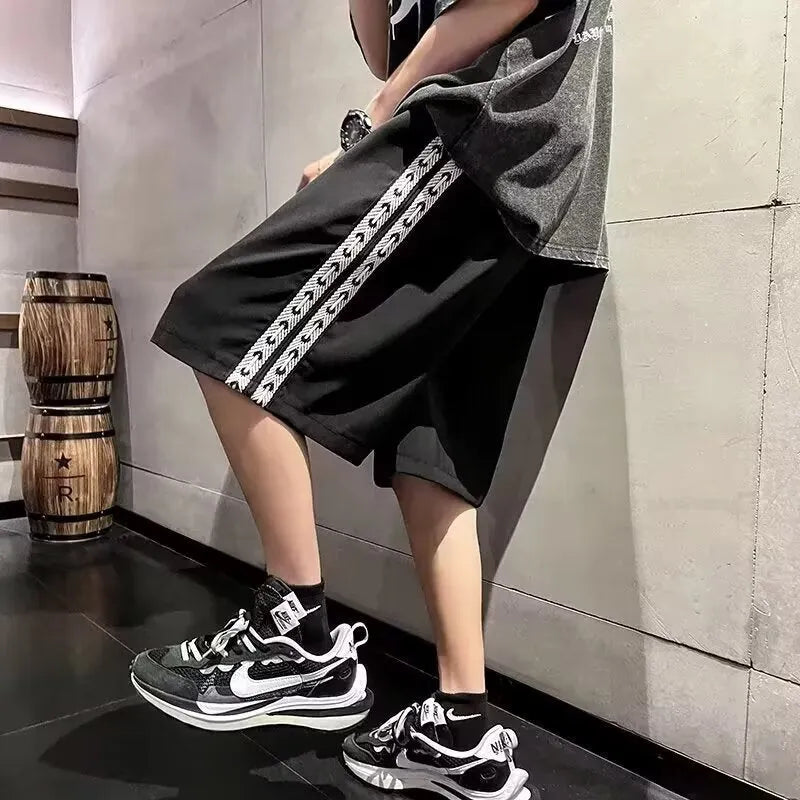Men's loose-fit track pants in black polyester with micro-elastic fabric and sports styling
