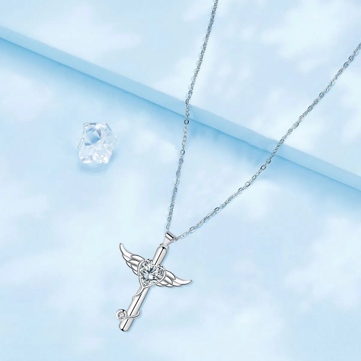 Close-up of a copper wings cross stethoscope pendant necklace on a chain.