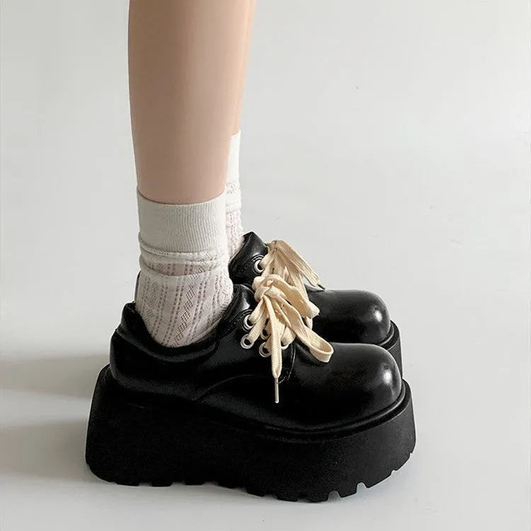 Matte black women's high-heel shoes with a thick rubber sole and lace-up buckle.