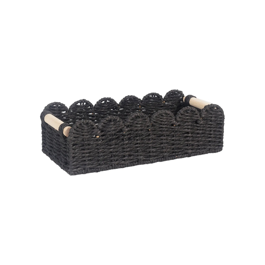 Woven paper storage basket in khaki colour on a desktop, holding remote controls and stationery.