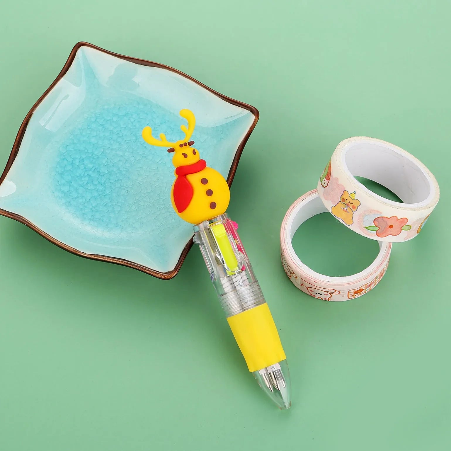 Christmas-themed ballpoint pen with press button, showing designs of snowmen, reindeer, and trees on plastic barrel.