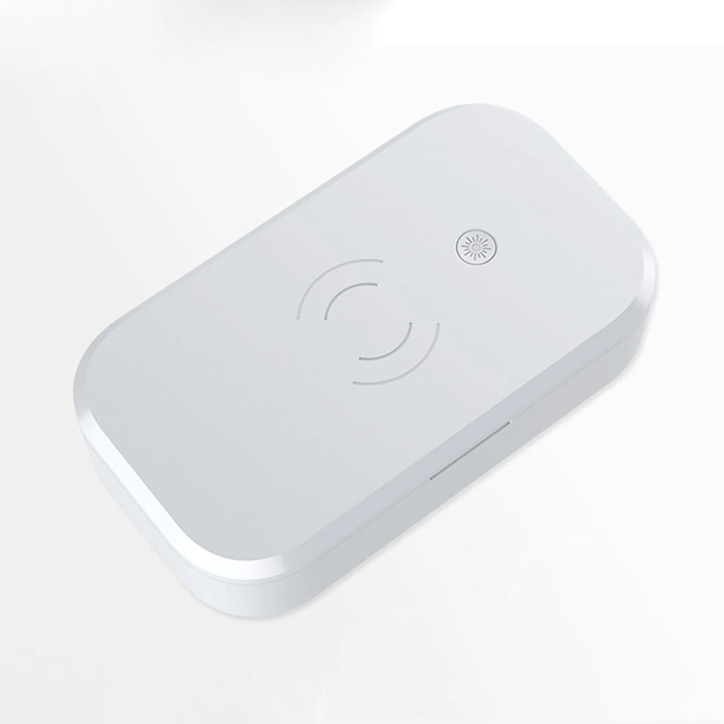 White ultraviolet disinfection box with wireless charging pad inside for phones and beauty tools.
