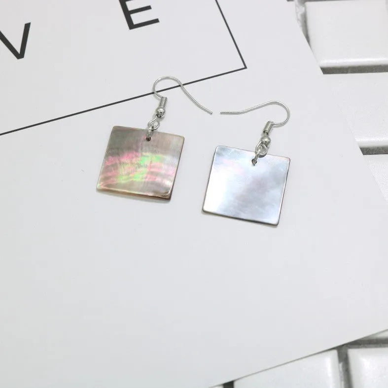 A pair of women's geometric earrings made from natural shell in a retro style.