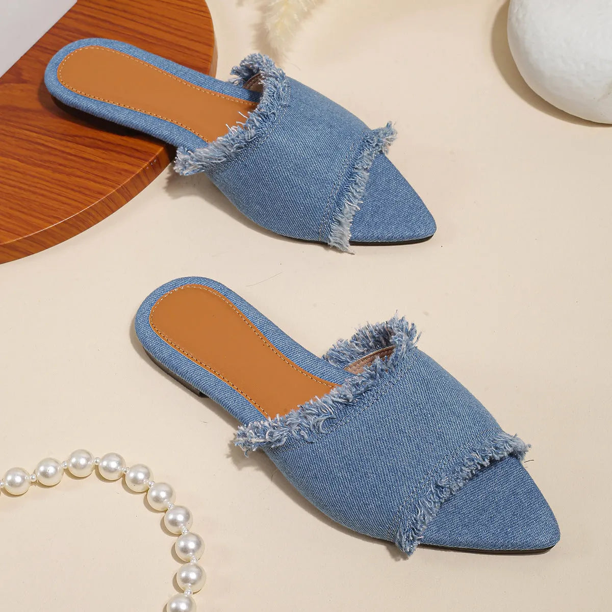 Women's denim flat slippers with tassel detail and leather lining in multiple colours.