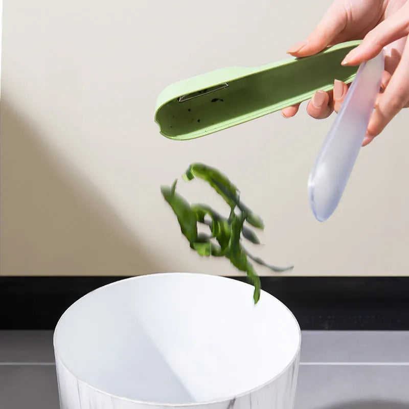 Green fruit and vegetable peeler with a storage tube and stainless steel blade.