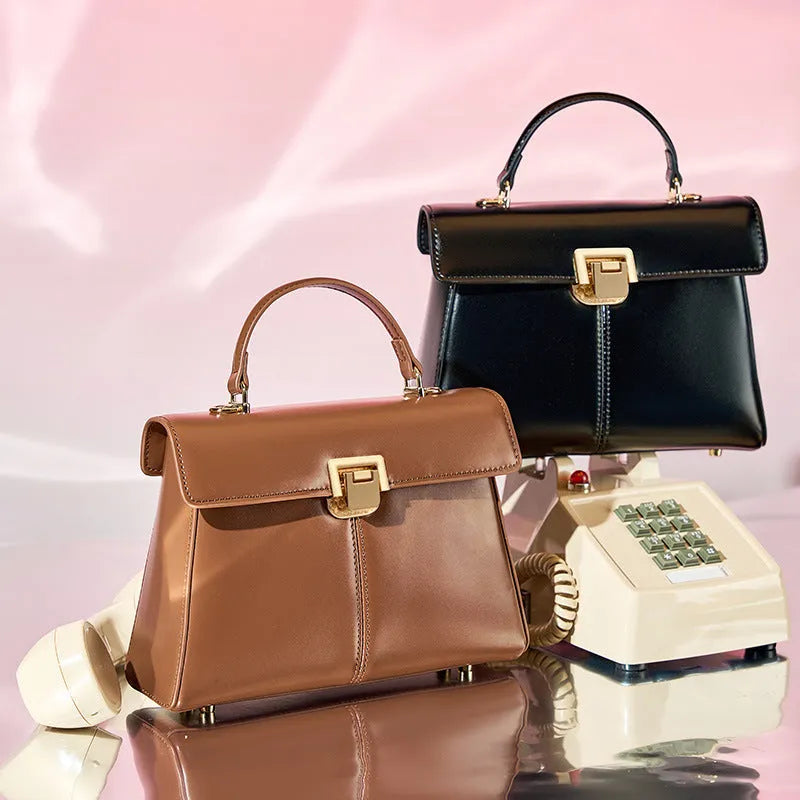 Black genuine vachette leather women's shoulder bag with clasp closure, showing square shape and adjustable strap.