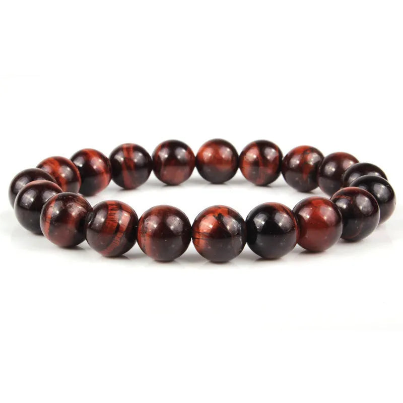 Tiger eye crystal stone bracelet showing round beads available in multiple colours and sizes on a wrist.