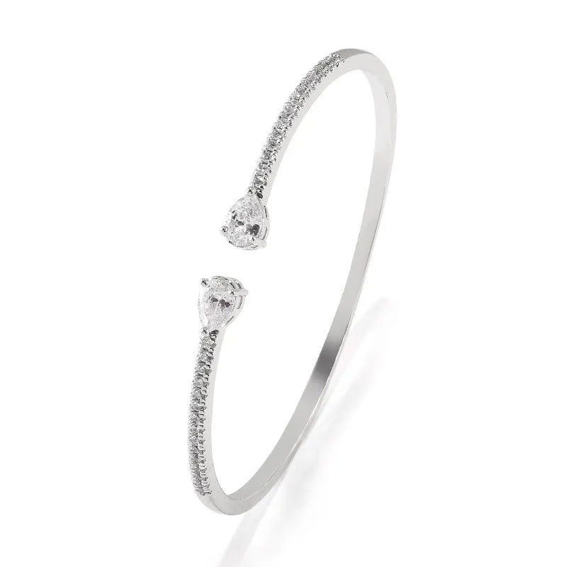 Copper bracelet with inlaid white zircon stones on a wrist.