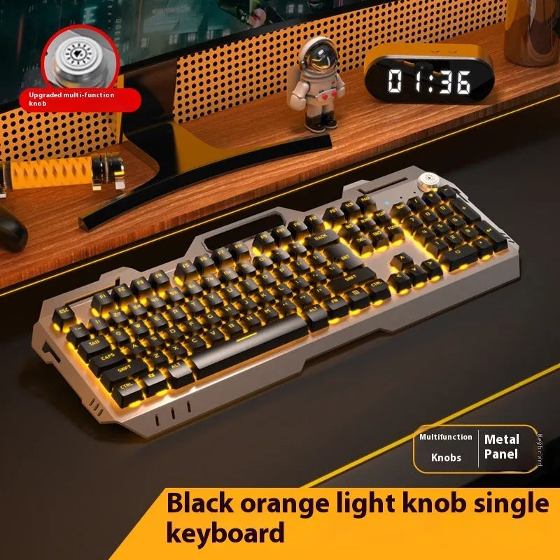 Aluminium gaming keyboard with volume knob, shown in metal grey with RGB lighting alongside optional macro mouse and headset.