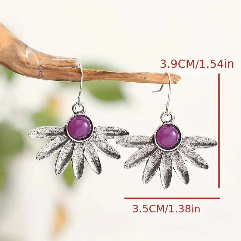 Close-up of purple Bohemian style flower earrings with resin gemstones and Zodiac animal detailing on alloy.