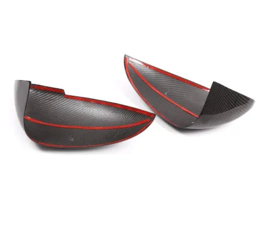 Glossy black true carbon fibre rearview mirror cover for Porsche Macan on a white background