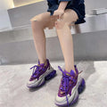 Women's green leather sports shoes with thick soles and cross-tie lacing on a white background.
