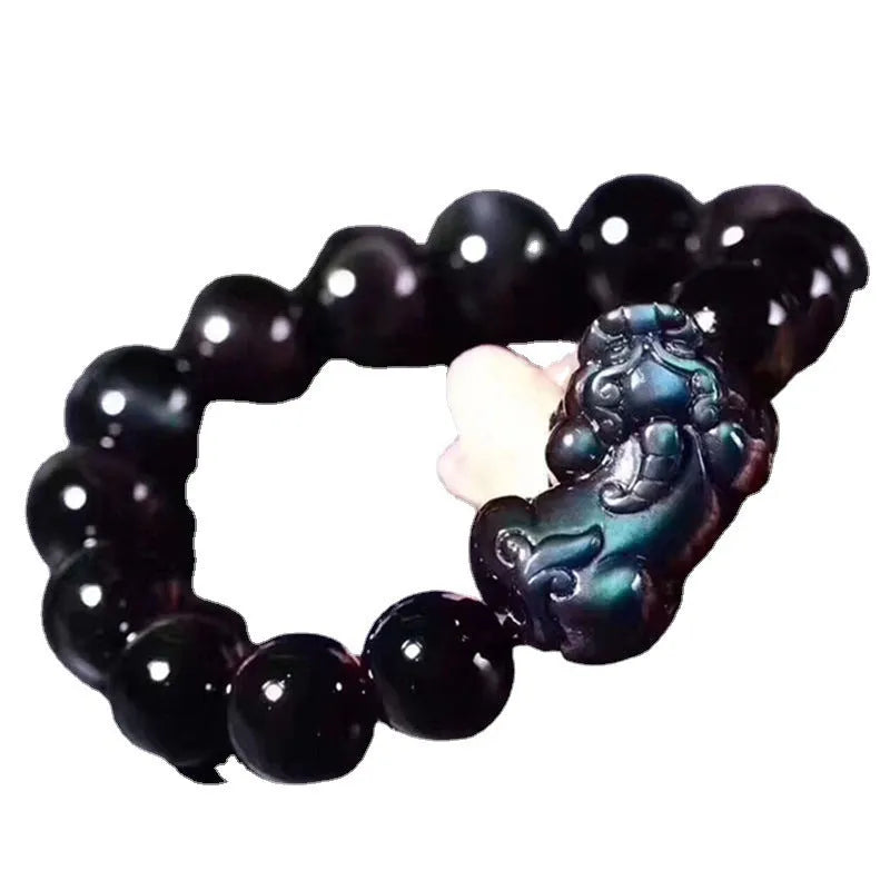 Natural obsidian stone bead bracelet with adjustable black cord on a wrist.