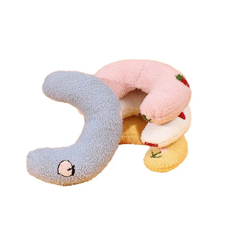 Blue U-shaped half moon cloth pillow for cats and dogs on a wooden floor.
