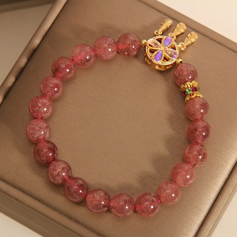 Women's bracelet with strawberry quartz beads and crystal accents featuring four-leaf dream catcher pendant