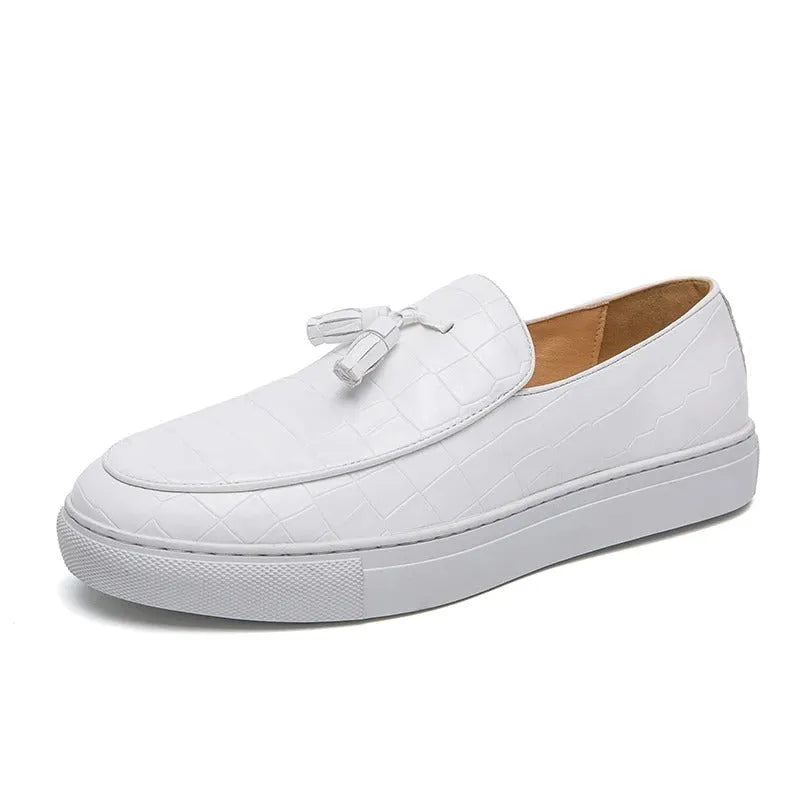 Men's black tassel detail slip-on sneakers on a white background, showing the round toe and elastic side.