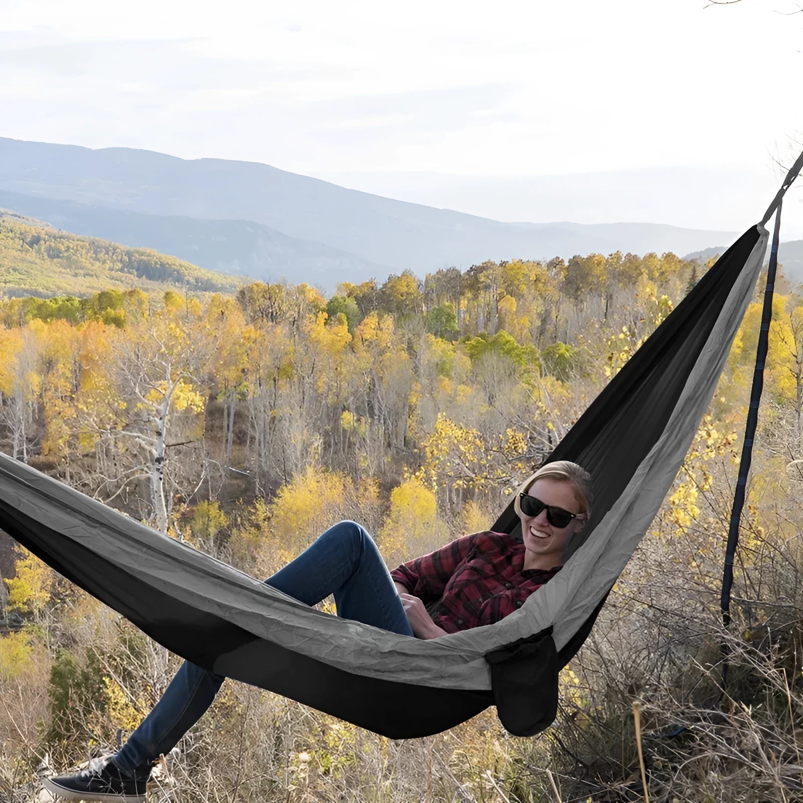 Double camping parachute hammock in 210T nylon black brown colour with tree straps and carabiners on outdoor setting