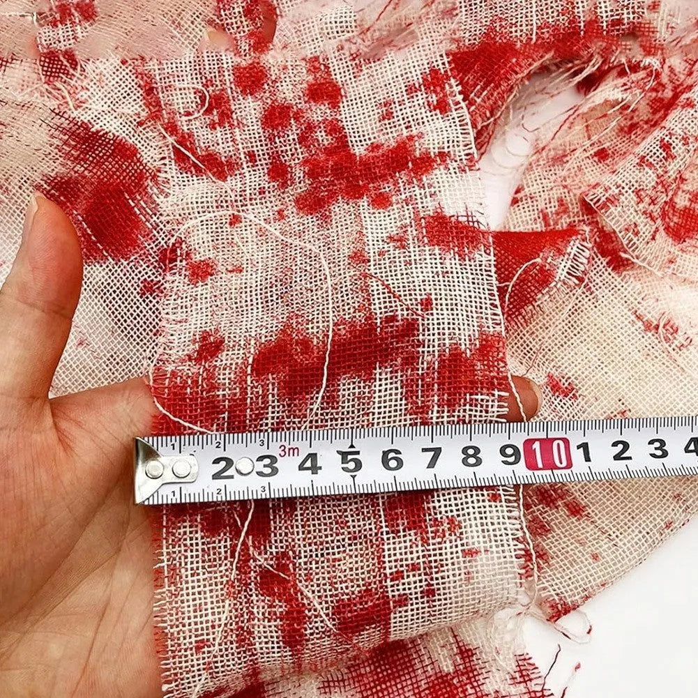 Roll of Halloween horror dyed gauze bandage in bloody red colour, shown with a loose end draped.