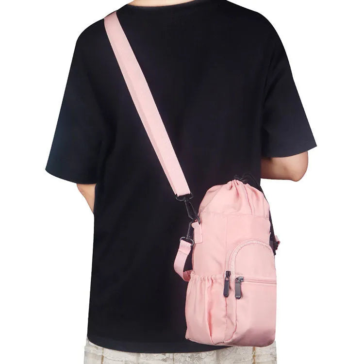 Black cloth water bottle pouch with crossbody strap and side handle on a model.