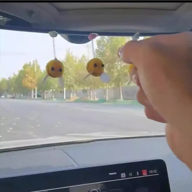 Spring-loaded bee car decoration with fur texture swinging from dashboard