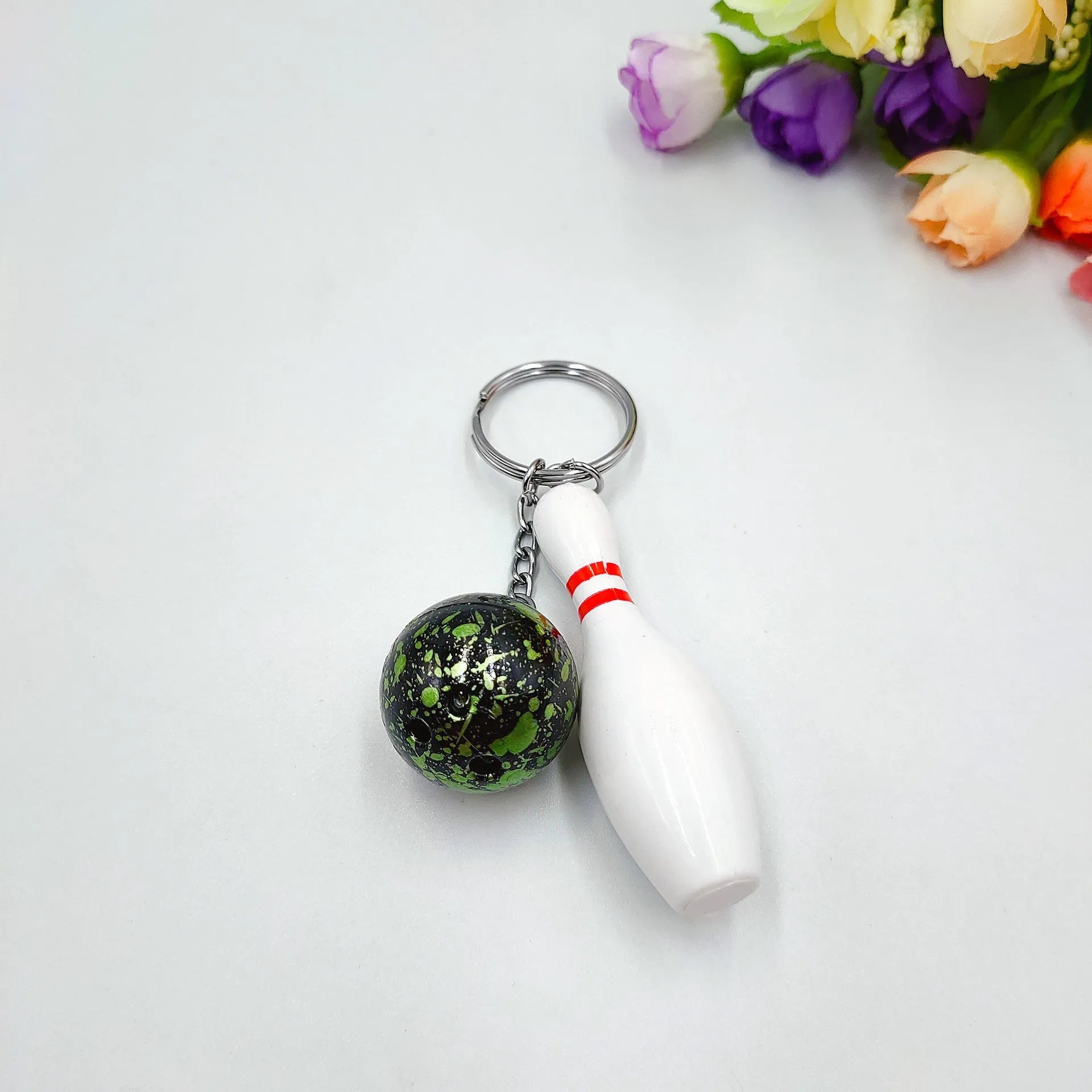 Mini sports bowling keychain pendant in PVC metal, shown in dark red, blue, purple, and green colour options.
