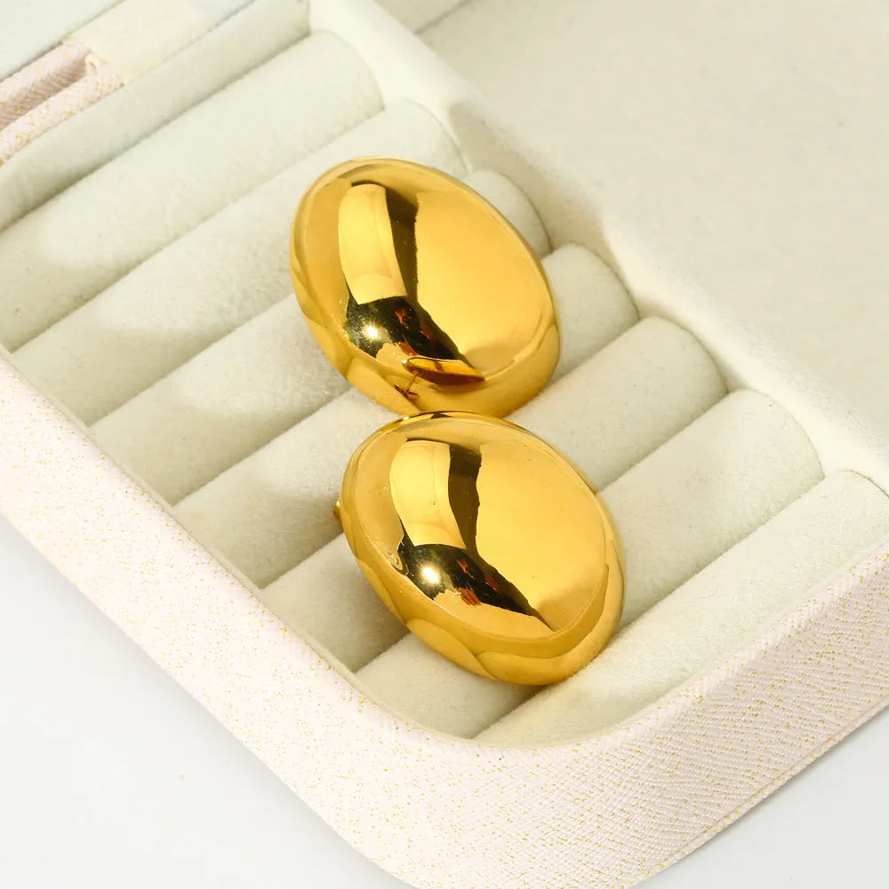 Close-up of simple geometric stainless steel stud earrings with 18K gold plated glazed finish and line design.