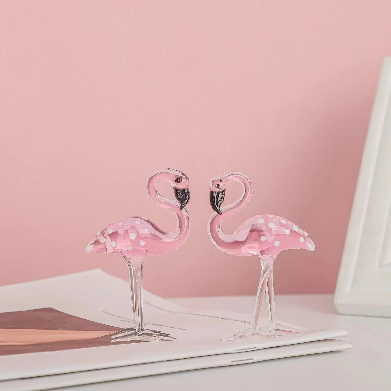 Pink crystal flamingo decorative ornament on table, available in separate or parallel styles.