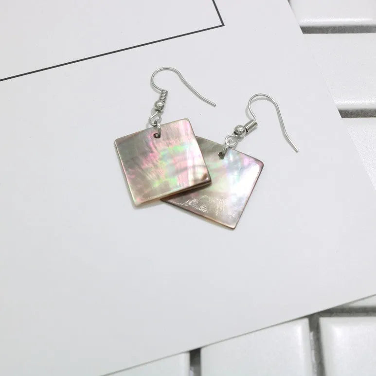 A pair of women's geometric earrings made from natural shell in a retro style.