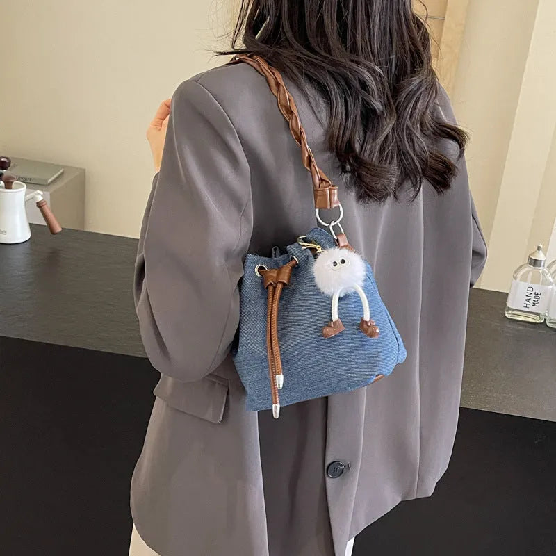 Blue one-shoulder cross body bucket messenger bag with an external sandwich pocket.