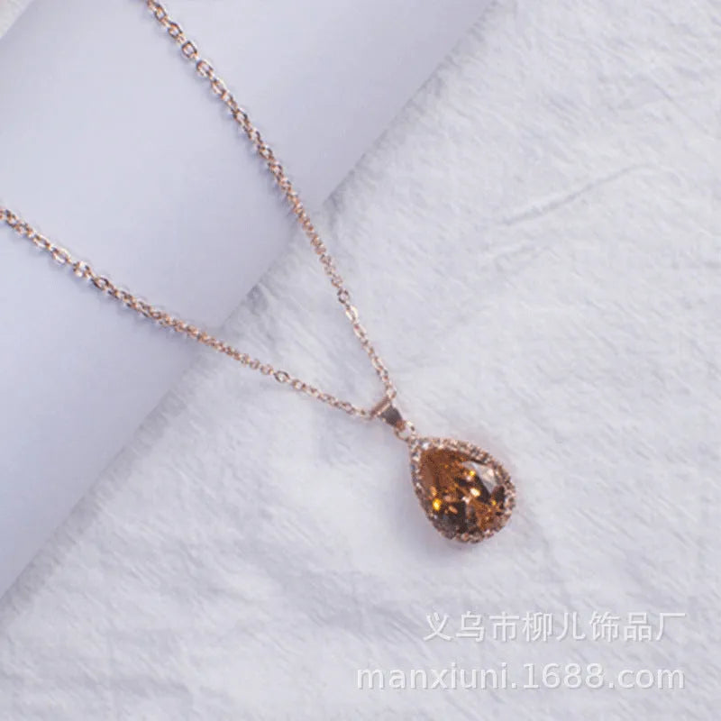 Pink water drop shaped rhinestone necklace with rose gold electroplated alloy pendant on white background