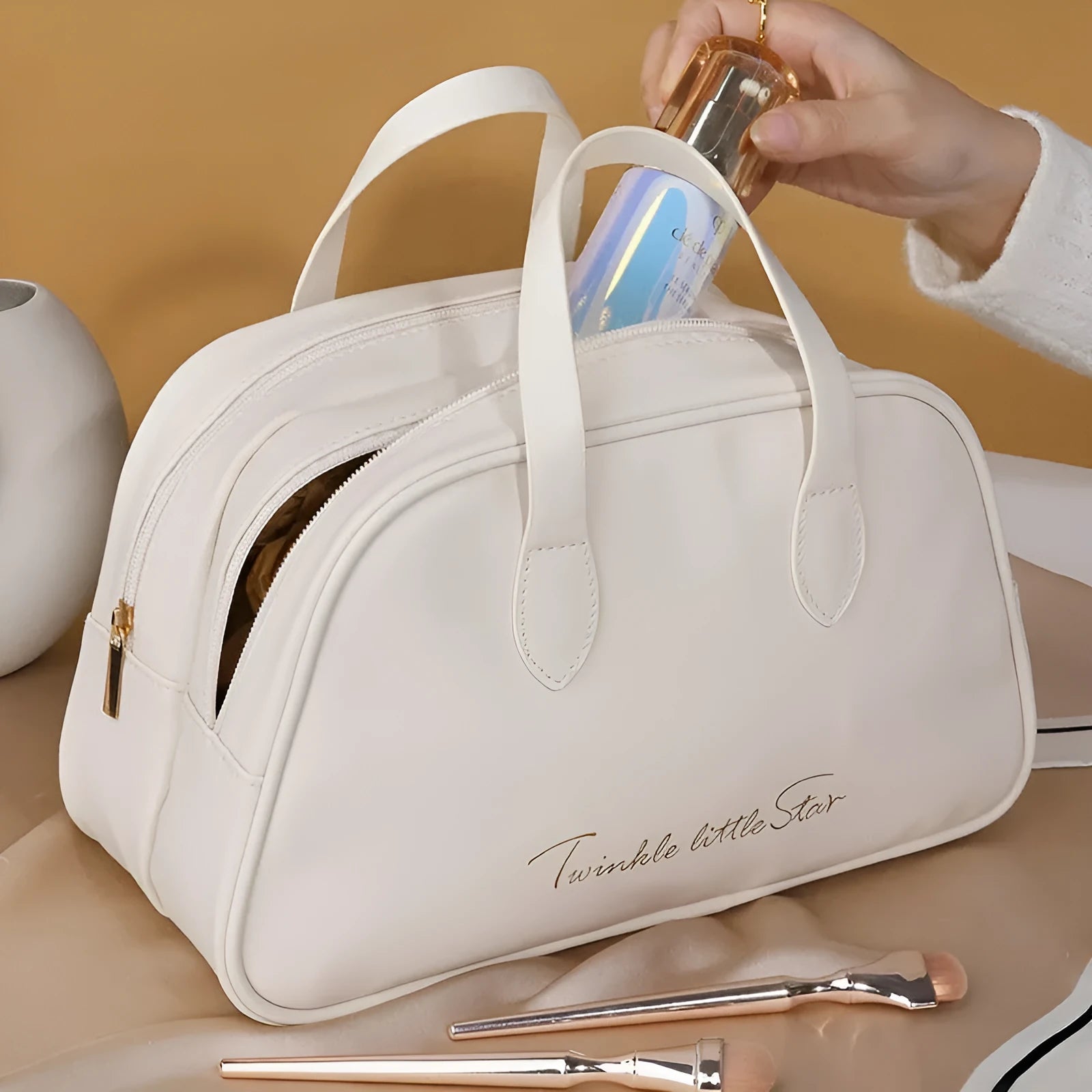 Leather travel toiletry bag in caramel mocha colour showing storage compartments and decorative letter details