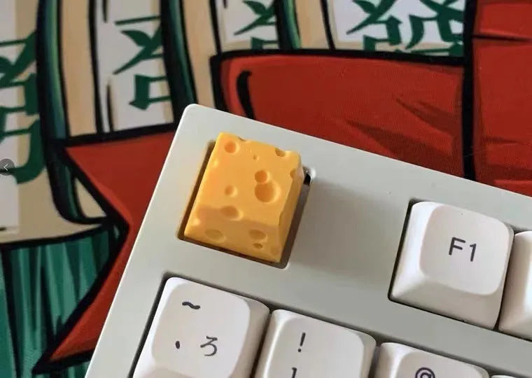 Yellow resin cheese artisan keycap for mechanical keyboards on a white background.
