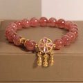 Women's bracelet with strawberry quartz beads and crystal accents featuring four-leaf dream catcher pendant