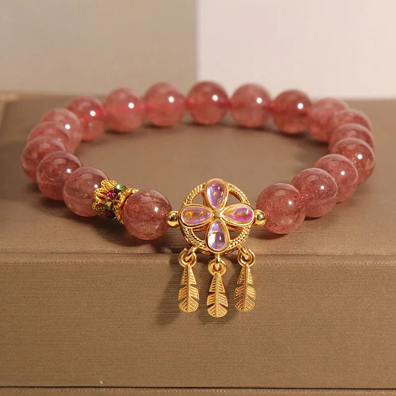 Women's bracelet with strawberry quartz beads and crystal accents featuring four-leaf dream catcher pendant