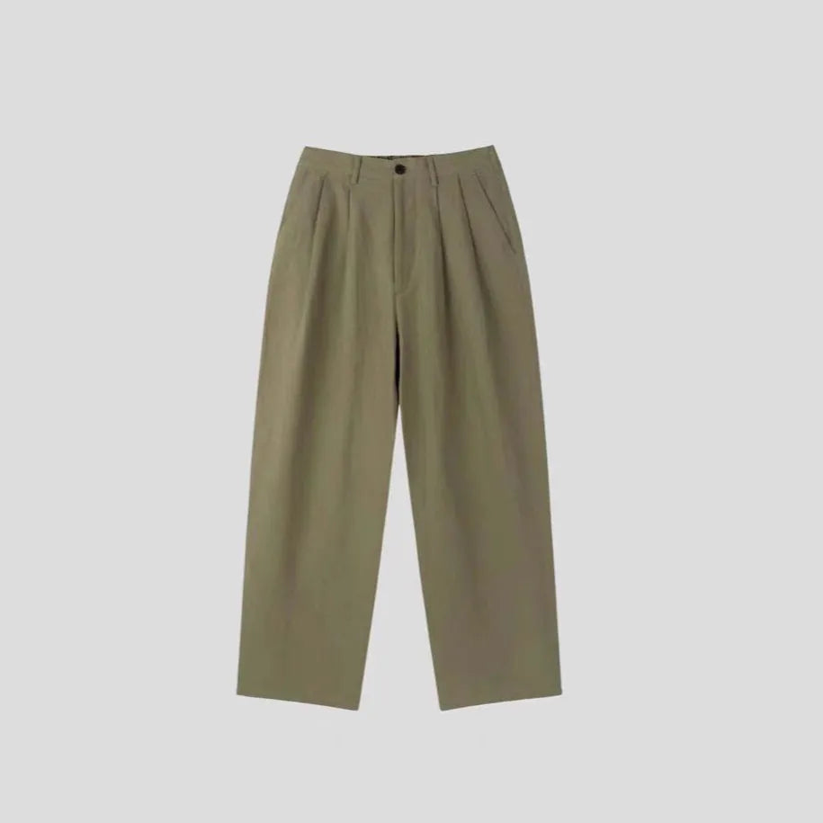 Men's lightweight apricot coloured wide-leg cotton linen trousers with a pencil leg opening on a hanger