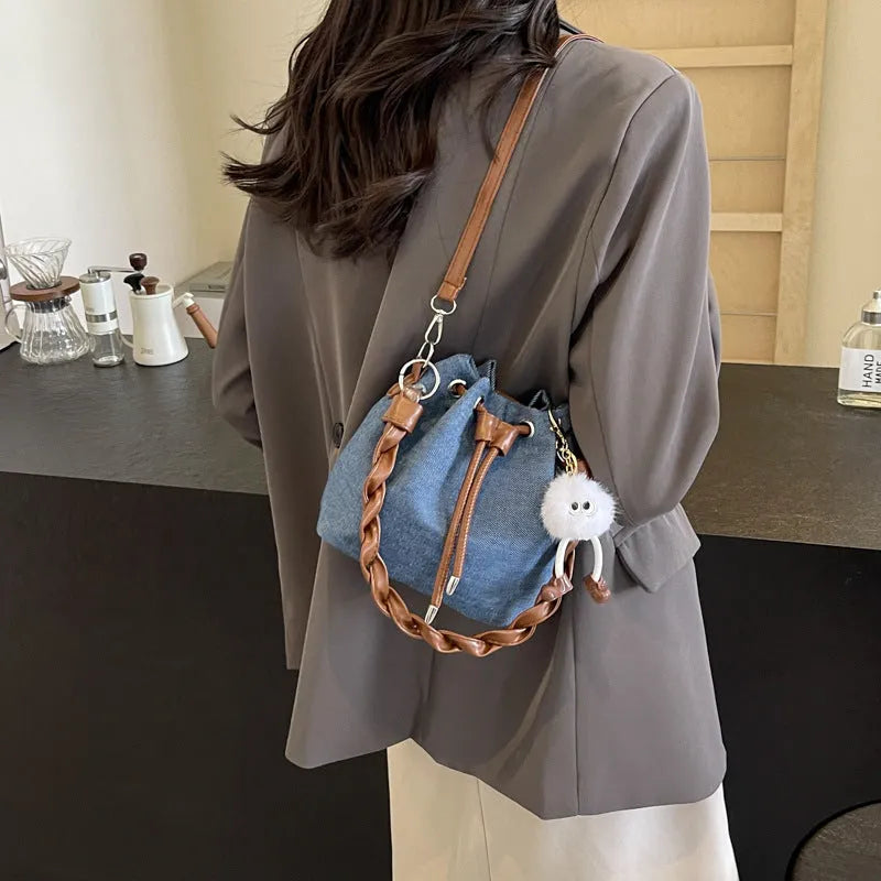 Blue one-shoulder cross body bucket messenger bag with an external sandwich pocket.