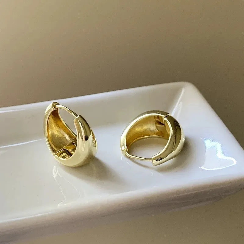 Pair of simple retro geometric alloy earrings in gold electroplated finish on a light background