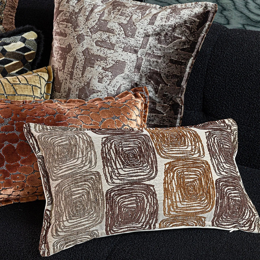 Cream and coffee coloured abstract coil pattern on two pillow sizes: a square cushion and a rectangular bolster.