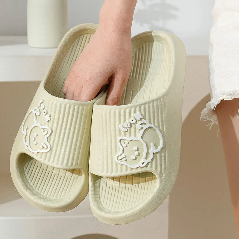 Green EVA platform flip flop slippers with a raised cat design on the upper.