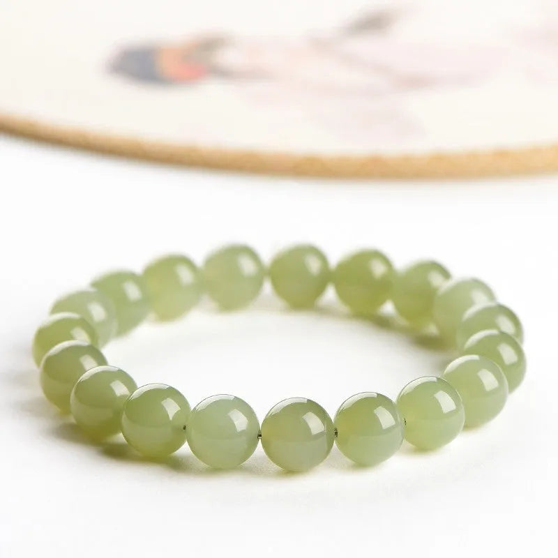 Polished Hetian jade beaded bracelet in ice-like clear water colour on a wrist.