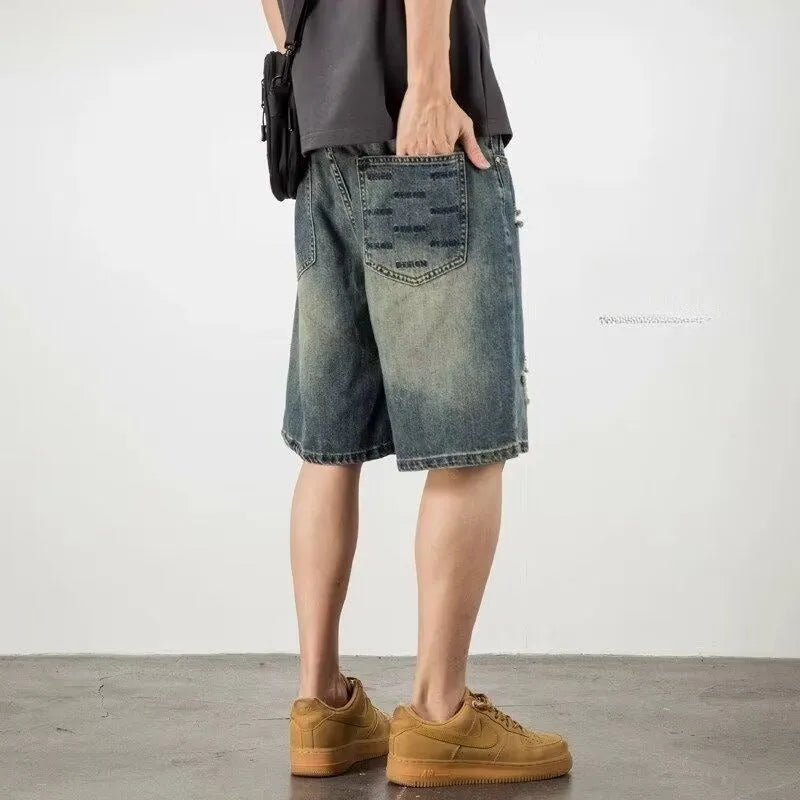 Man wearing blue retro distressed denim shorts with a straight leg cut.