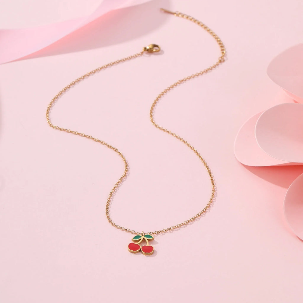 Cherry-themed jewellery set showing stainless steel necklace, bracelet, earrings, and ring with 18K gold plating.