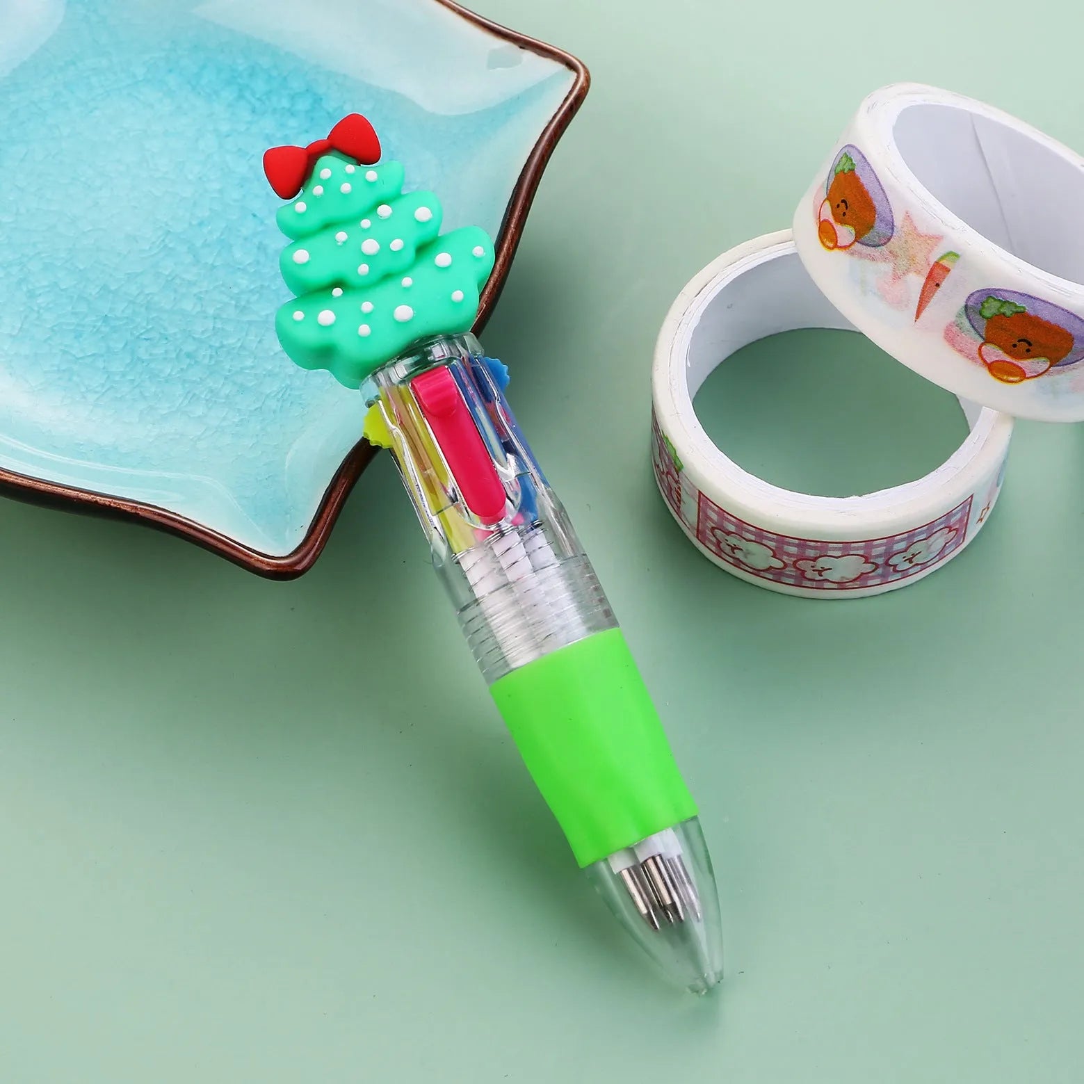 Christmas-themed ballpoint pen with press button, showing designs of snowmen, reindeer, and trees on plastic barrel.