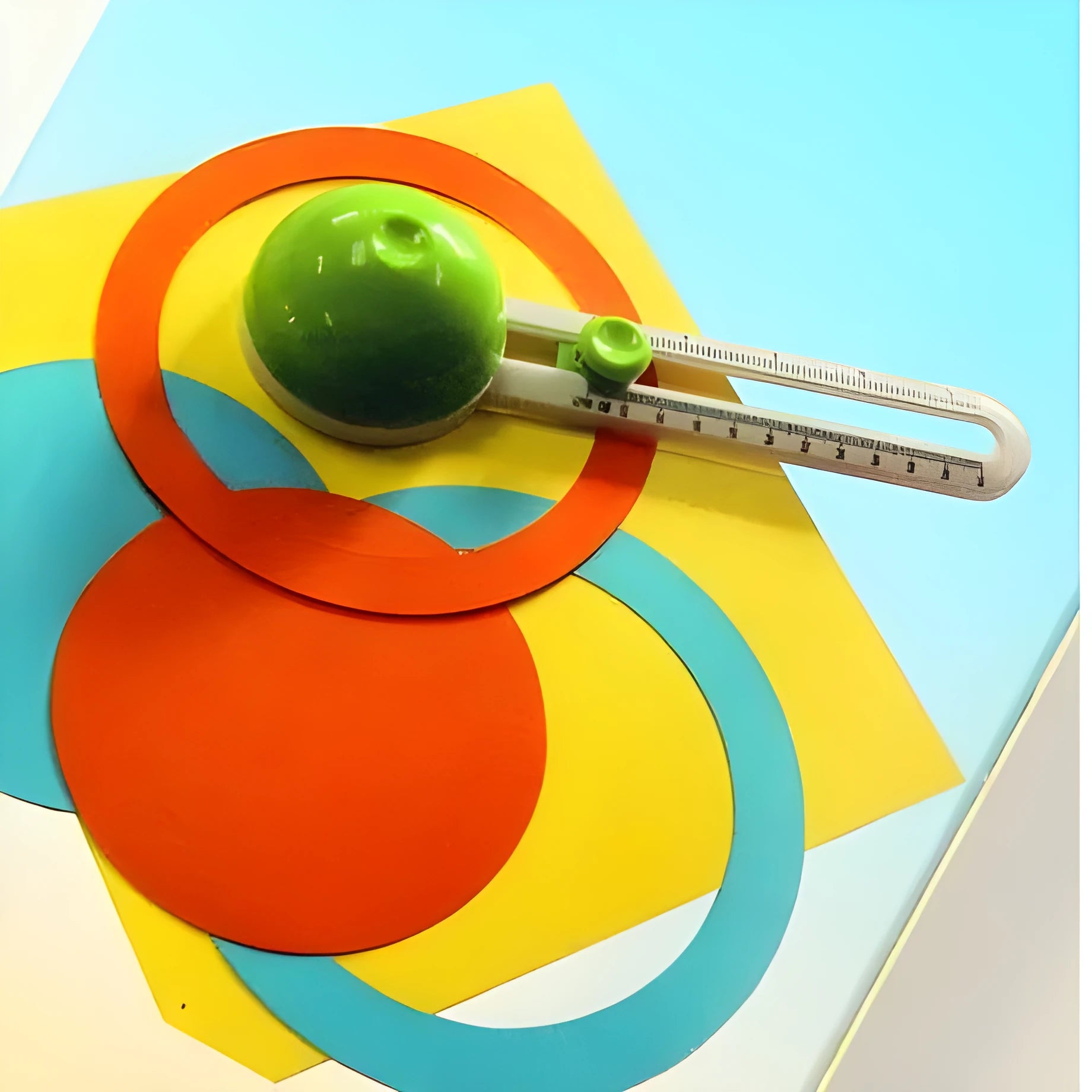 Green and orange plastic round paper cutter for A3 sheets on a colour box.