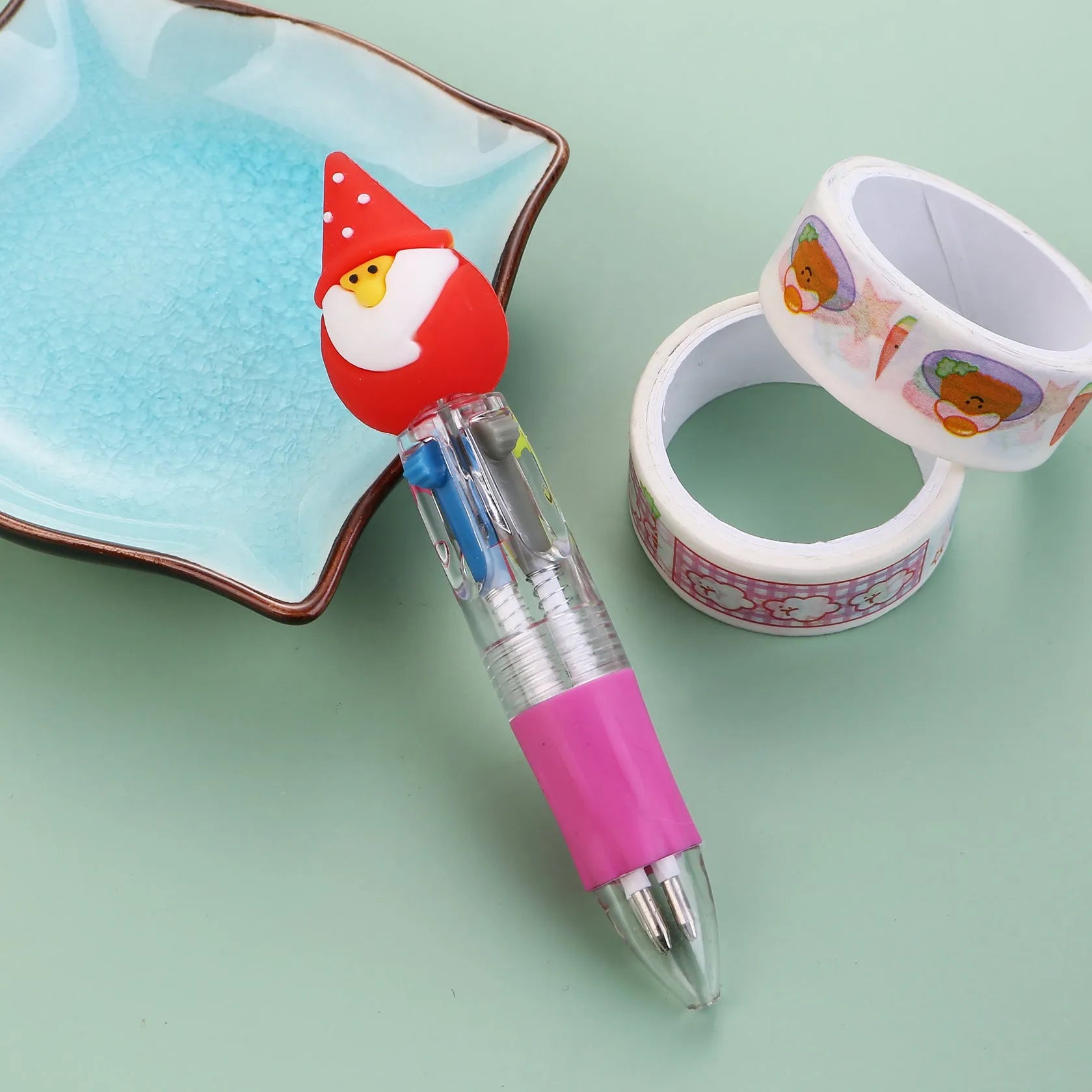 Christmas-themed ballpoint pen with press button, showing designs of snowmen, reindeer, and trees on plastic barrel.