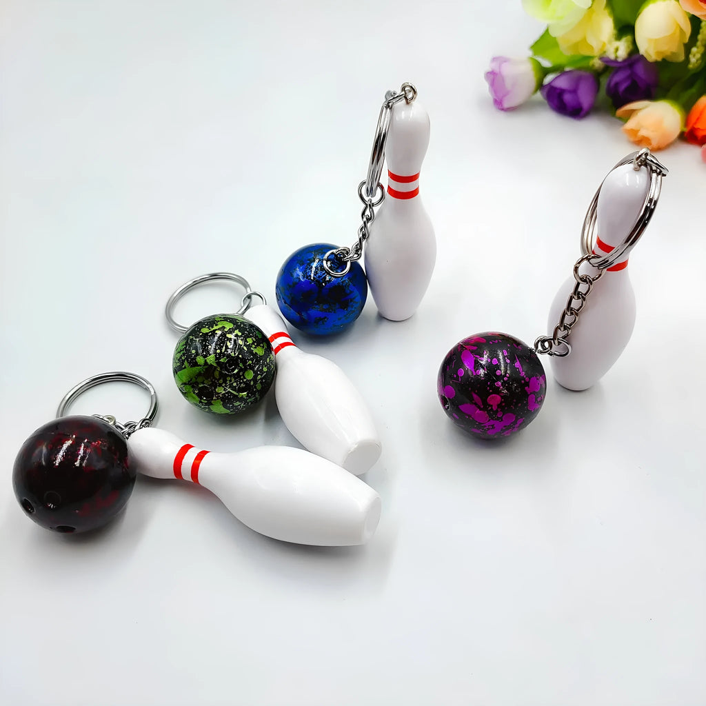 Mini sports bowling keychain pendant in PVC metal, shown in dark red, blue, purple, and green colour options.