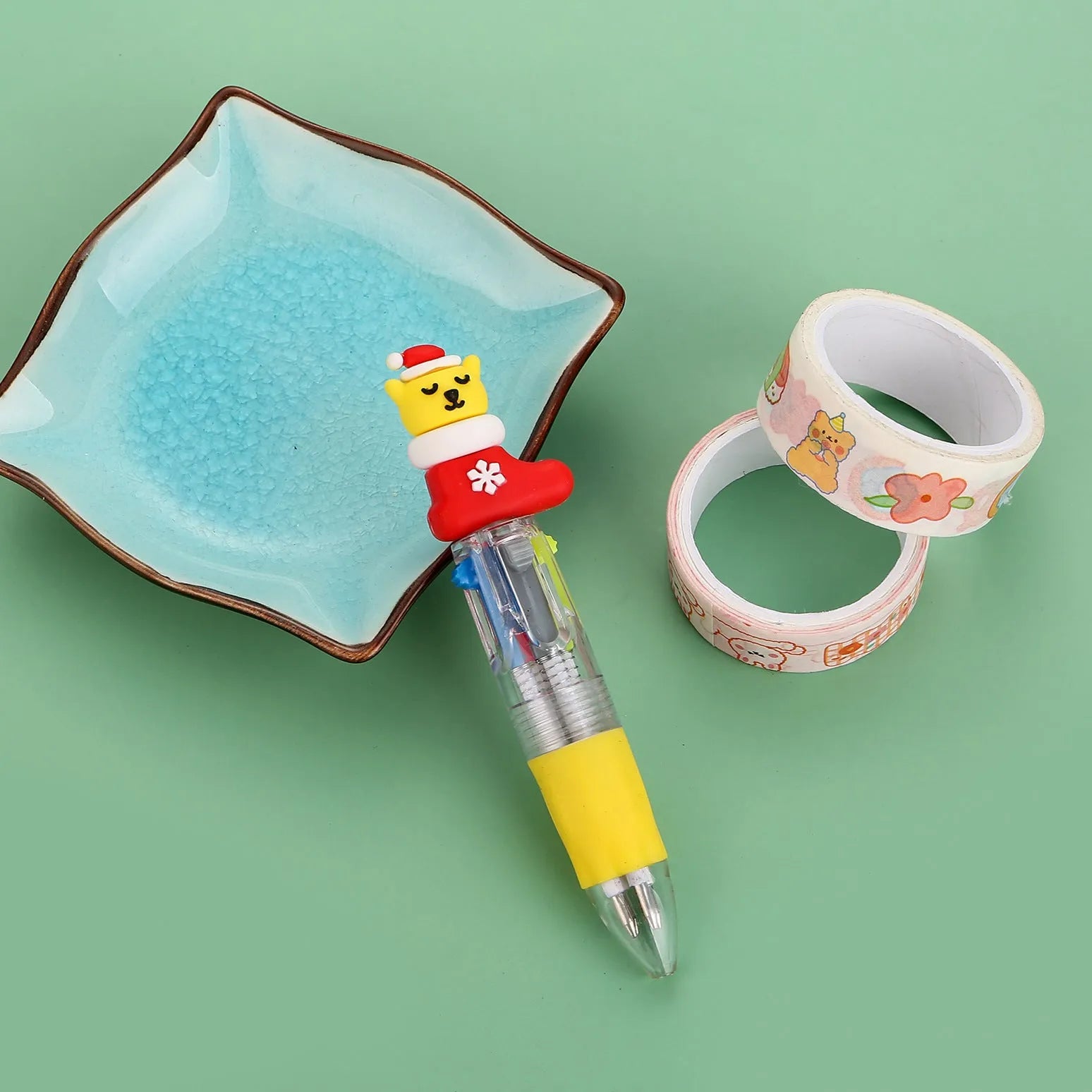 Christmas-themed ballpoint pen with press button, showing designs of snowmen, reindeer, and trees on plastic barrel.