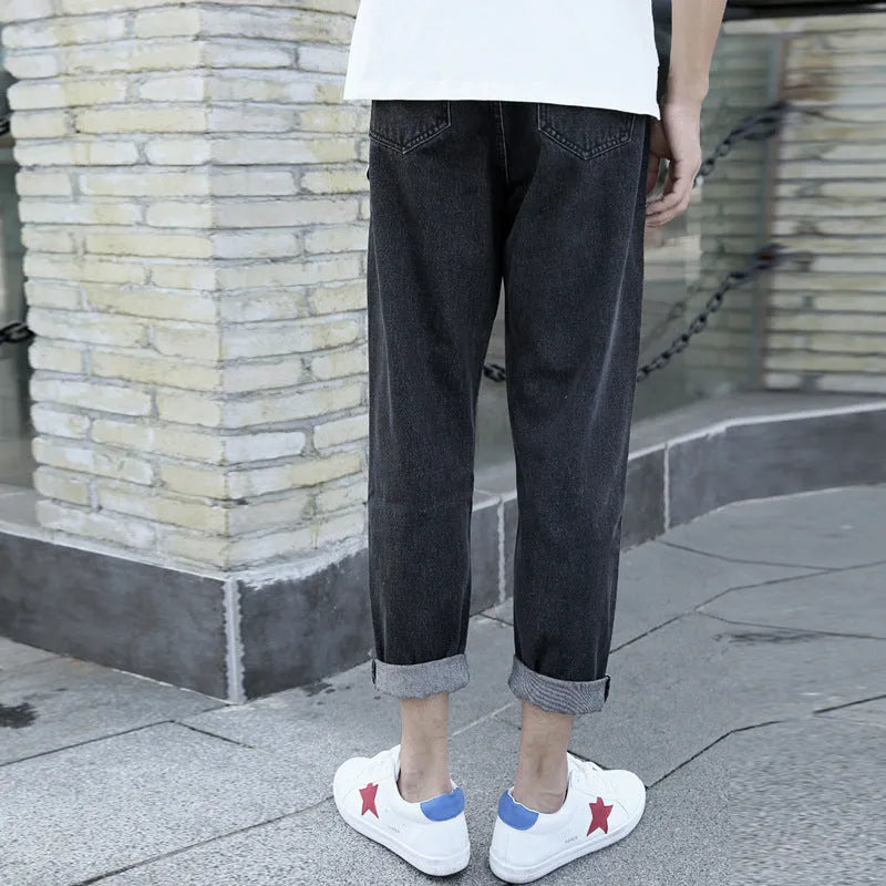 A pair of men's loose straight-leg jeans in a blue colour on a plain background.